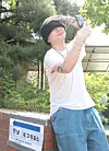 Rapper Woo, whose real name is Woo Won-jae, takes a photo beside a polling station sign in Hannam-dong in Yongsan District, central Seoul, on June 3. [NEWS1]