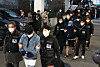 Suspects involved in Cambodian scam networks who were forcibly repatriated to Korea arrive at Dongnae Police Station in Busan on Jan. 23. [YONHAP]