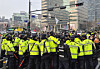 Members of Solidarity Against Disability Discrimination stage a boarding protest at a crosswalk near a bus stop in Gwanghwamun in Jongno District, Seoul, on March 27, as police manage the demonstration during morning commute hours. [YONHAP]