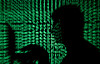 A man holds a laptop computer as cyber code is projected onto him in this illustration from May 13, 2017. [REUTERS/YONHAP]