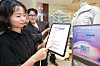 A Hyundai Department Store employee uses a generative AI shopping assistant called “Heydi” to offer personalized offline shopping recommendations to customers. [YONHAP]