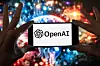 The OpenAI logo is seen displayed on a cell phone in front of an image on a computer screen generated by ChatGPT's Dall-E text-to-image model in Boston on Dec. 8, 2023. [AP/YONHAP]