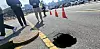 A sinkhole is seen on a road near the government complex in Eojin-dong, Sejong, on March 23. Police controlled the road while Sejong officials discussed response measures. [NEWS1]
