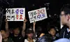 People hold signs that there was election fraud for the local elections gather in front of the Polling Station No. 2 in Jamsil 7-dong in southern Seoul on June 4. [YONHAP]