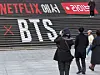 A tourist takes a photo of an advertisement for a BTS concert installed on the steps of the Sejong Center next to Gwanghwamun Square in Jongno District, central Seoul, on March 8. [IM SOUNG-BIN]