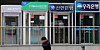 A person walks in front of major banks' ATM booths in central Seoul on Feb. 22. [NEWS1]