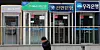 A person walks in front of major banks' ATM booths in central Seoul on Feb. 22. [NEWS1]