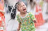 A child frolics in a water fountain in central Seoul on May 25. [NEWS1]