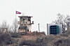 A soldier stands at a North Korean military guard post flying a national flag, seen from Paju, Gyeonggi on Feb. 26. [AP/YONHAP]