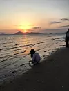 Me when I was in first grade, touching seawater in front of a sunset in Dadaepo Beach. [LEE EUNJAE]