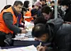 Older people are seen filling out job applications at a job fair held at the Mapo District Office in Mapo District, western Seoul, on Dec. 10, 2025. [YONHAP]