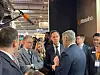 Bart De Wever and Mark Rutte talk with others at the Hanwha booth during a defense exhibition in Brussels.