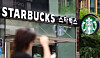 Starbucks cafe sign and logo on a storefront in Seoul.