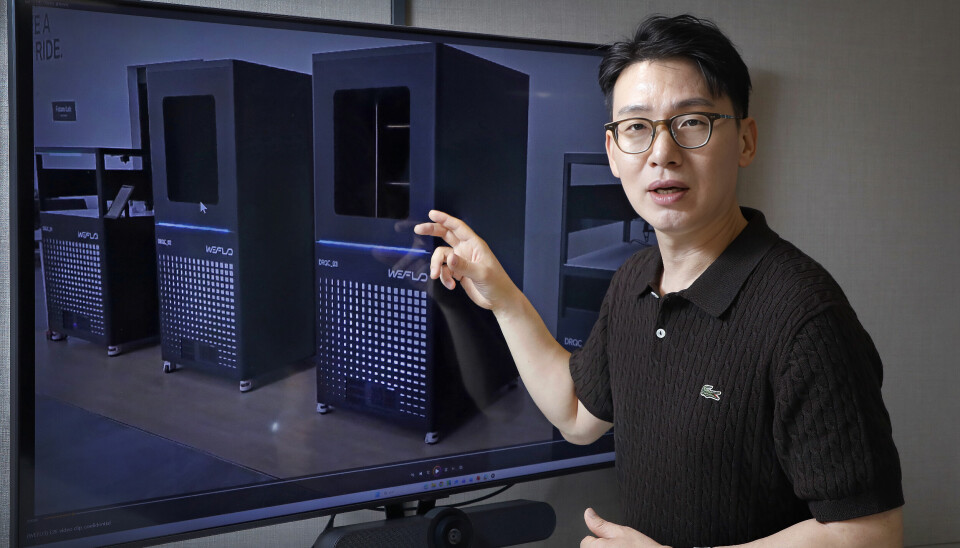 Man pointing at a screen displaying server racks in a data center.