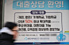 A pedestrian walks past a loan advertisement posted at a Saemaul Geumgo branch in Seoul on March 8. [YONHAP]