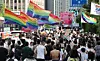 Participants in the 26th Seoul Queer Culture Festival hold up rainbow flags as they march up a road near Myeongdong Cathedral in Jung District, central Seoul, on June 14, 2025. [NEWS1]