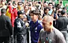 South Korean football players and staff arrive at a Guadalajara hotel amid photographers and security.