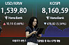 Electronic board at Hana Bank dealing room in Seoul displays plunging KOSPI and KOSDAQ figures.