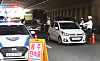 Police officers check drivers at a daytime sobriety checkpoint on a road in Suwon.