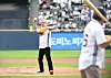 Jensen Huang throws a ceremonial first pitch on the mound at a baseball game with a crowd in the stands.