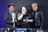 Jensen Huang stands with two people after presenting an RTX Spark laptop voucher at a PC cafe in Seoul.