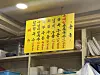 Yellow handwritten Korean sign hanging above shelves in an indoor room.