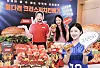 Models hold up new Lotte리아 crispy chicken burgers and flavor signs at a promotional event.