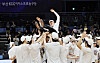 Basketball players lift coach Lee Sang-min in celebration on the court after a championship win.