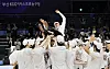 Basketball players lift coach Lee Sang-min in celebration on the court after a championship win.