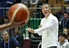 South Korea basketball coach Heo Jae in a white tracksuit arguing with a referee during a game.
