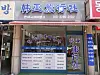 Korean travel agency storefront with signs, glass doors, and posted information.