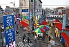 People walking through a street market lined with colorful umbrellas and Korean shop signs.