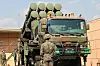 Military personnel raise a Cheongung-II missile launcher beside a truck at an Air Force base.