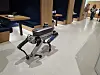 Quadruped robot standing on a polished floor in a modern indoor setting.