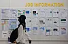 A person walks in front of a job-post board in a college in Seoul on June 11.