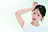 A woman is frowning and clenching her head. [GETTY IMAGE BANK]