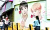 A person takes a photo in front of a mural of BTS members Jungkook and Jimin in Seo District, Busan, on March 19. [NEWS1]