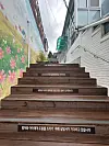 A wooden flight of stairs leading up to the baby box at Jusarang Community in Gwanak District, southern Seoul, on May 11 is adorned with sympathetic phrases such as, “A counselor is waiting to help mothers and children,” “Consultation guides mothers and children toward safety” and “Thank you for choosing to protect your baby.' [SHIN MIN-HEE]