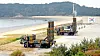 Two Cheongung-II missile systems and support vehicles positioned on a sandy Korean shoreline.