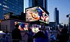 People watch a digital billboard display a Christmas-themed video featuring the city mascot, Hechi, during the 2025 Gangnam Media Winter Festa near Samseong Station in southern Seoul on Dec. 22, 2025. [WOO SANG-JO]
