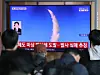 People in a station watch a TV broadcast about North Korea's missile launches.