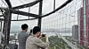Riders on the Seouldal hot-air balloon take photos of the view. [WOO JI-WON]