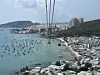 Cable car cabins glide over the turquoise waters of Phu Quoc, Vietnam, offering visitors a bird’s-eye view of Sunset Town’s European-inspired architecture and the traditional fishing village below. [SEO JI-EUN]
