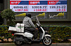 A person looks at a stock price monitor showing New York Dow and Nikkei indexes and the dollar-Japanese yen exchange rate at a security company on March 17, 2026, in Tokyo. [AP/YONHAP]