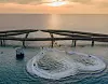 The Kiss Bridge in Sunset Town, Phu Quoc, is complemented by jet skiers performing in the surrounding waters. [SUN GROUP]