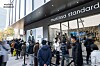 Crowd waiting outside a Musinsa Standard store entrance on a city sidewalk.