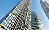 Low-angle view of several modern glass skyscrapers against a clear blue sky.