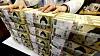 Bundles of 50,000 won ($33) bills are piled up in a commercial bank in central Seoul on Feb. 24.