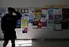A person walks in front of a bulletin board where recruitment opportunities are posted in a college in Seoul on June 11.
