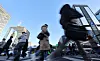 People walk on a crosswalk in central Seoul during morning rush hours on Feb. 19.